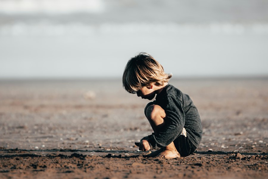 A child sitting alone on the sand