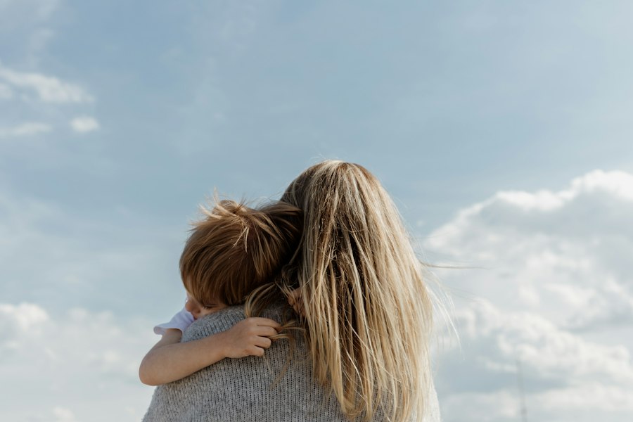 A child hugging a parent against the sky